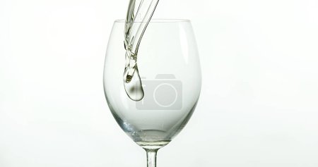 Téléchargez les photos : Vin blanc versé dans le verre, sur fond blanc - en image libre de droit