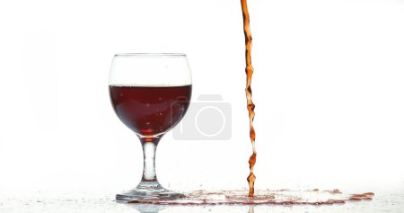 Téléchargez les photos : Vin rouge versé dans le verre, sur fond blanc - en image libre de droit