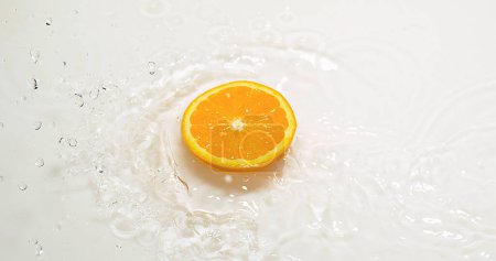Téléchargez les photos : Orange, agrumes sinensis, tranches tombant sur l'eau et éclaboussures, sur fond blanc - en image libre de droit