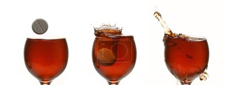 Photo for Tablet Falling into a Glass of red Wine against White Background - Royalty Free Image