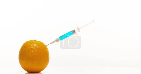 Téléchargez les photos : Seringue injectant le traitement dans l'orange, agrumes sinensis, fruits sur fond blanc - en image libre de droit