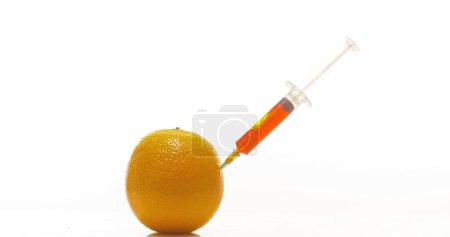 Téléchargez les photos : Seringue injectant le traitement dans l'orange, agrumes sinensis, fruits sur fond blanc - en image libre de droit