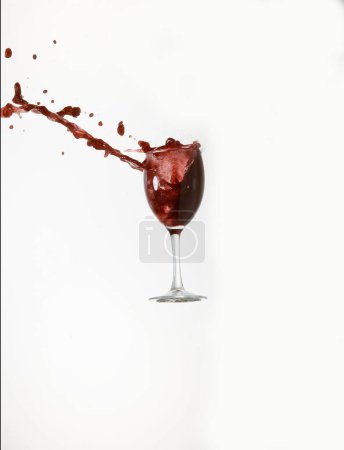 Foto de Copa de vino tinto rompiendo y salpicando contra fondo blanco - Imagen libre de derechos