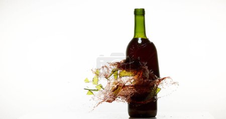 Téléchargez les photos : Bouteille de vin rouge cassant et éclaboussant sur fond blanc - en image libre de droit