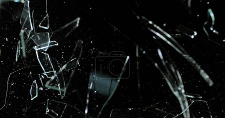 Téléchargez les photos : Volet de rupture de balle de tennis de verre sur fond noir - en image libre de droit