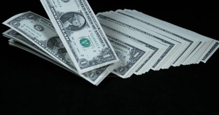 Téléchargez les photos : Billets de 1 dollar américain tombant sur fond noir - en image libre de droit