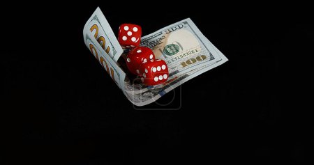 Photo for Red Dice rolling on Dollar Bills against Black Background - Royalty Free Image