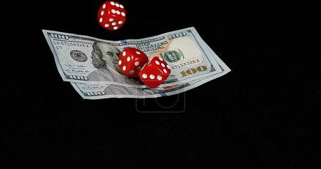 Photo for Red Dice rolling on Dollar Bills against Black Background - Royalty Free Image