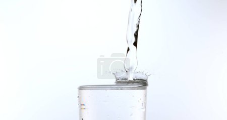 Photo for Water being poured into Glass against White Background - Royalty Free Image