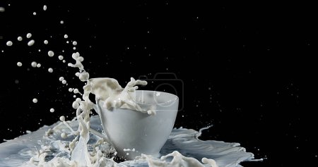 Photo for Bowl with Exploding Milk against Black Background - Royalty Free Image