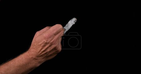 Téléchargez les photos : Main d'homme avec un doigt qui brûle comme une cigarette - en image libre de droit