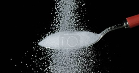 Photo for White Sugar falling against Black Background - Royalty Free Image
