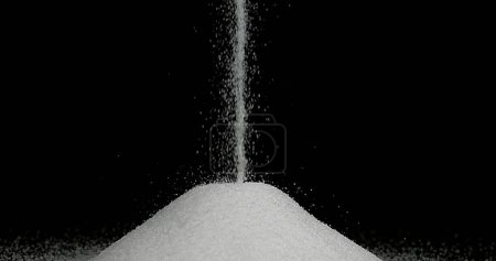 Foto de Azúcar blanco cayendo sobre fondo negro - Imagen libre de derechos