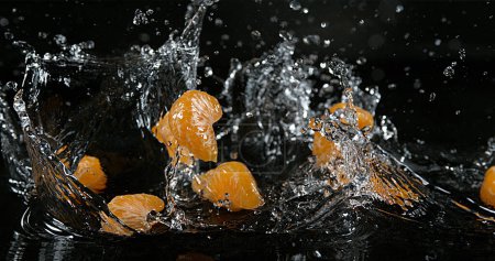 Foto de Clementinas, cítricos reticulados, Frutas que caen sobre el agua contra fondo negro - Imagen libre de derechos