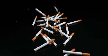 Photo for Cigarettes Falling against Black Background - Royalty Free Image