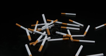 Photo for Cigarettes Falling against Black Background - Royalty Free Image