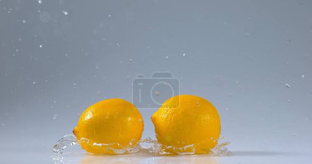 Téléchargez les photos : Citrons jaunes, limonum d'agrumes, fruits tombant sur l'eau - en image libre de droit