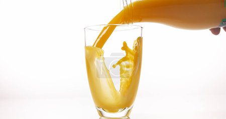 Photo for Orange Juice being poured into Glass against White Background - Royalty Free Image
