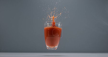 Foto de Caída del vaso de jugo de tomate - Imagen libre de derechos