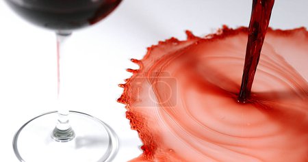 Photo for Red Wine being poured into Glass, against White Background - Royalty Free Image