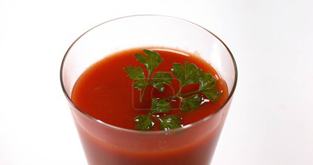 Foto de Perejil, Petroselinum crispum, cayendo en el jugo de tomate - Imagen libre de derechos
