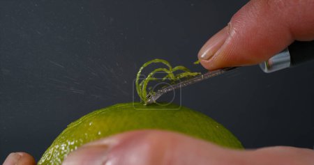 Foto de Green Lemon Zest, citrus aurantifolia, contra el fondo negro, - Imagen libre de derechos