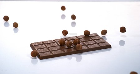 Foto de Avellanas cayendo en la tableta de chocolate con leche - Imagen libre de derechos