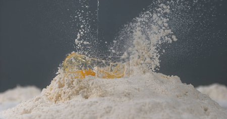 Photo for Egg Falling on Flour - Royalty Free Image