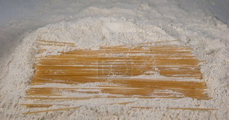 Téléchargez les photos : Spaghetti Pâtes tombant sur la farine - en image libre de droit