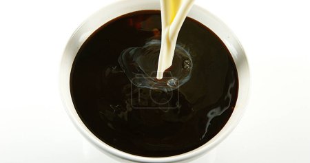 Photo for Milk poured into a Cup of Coffee against White Background - Royalty Free Image