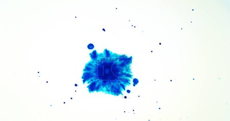 Foto de Líquido azul cayendo en el agua contra fondo blanco - Imagen libre de derechos