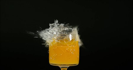Photo for Glass of Orange Exploding against Black Background - Royalty Free Image