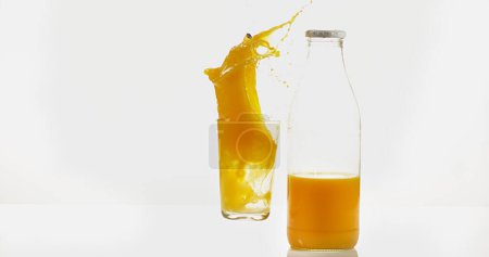 Foto de Vidrio y botella de naranja contra fondo blanco - Imagen libre de derechos