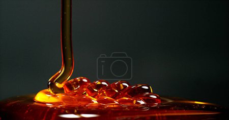 Photo for Honey Flowing against Black Background - Royalty Free Image