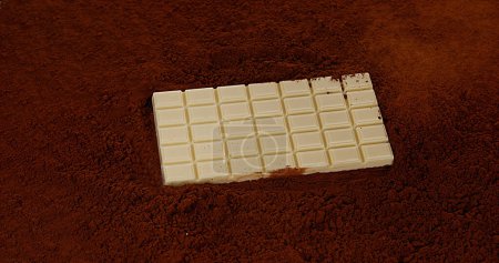 Photo for White Chocolate Tablet falling on Black Chocolate Powder - Royalty Free Image
