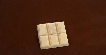 Foto de Tableta de chocolate blanco cayendo en chocolate con leche - Imagen libre de derechos