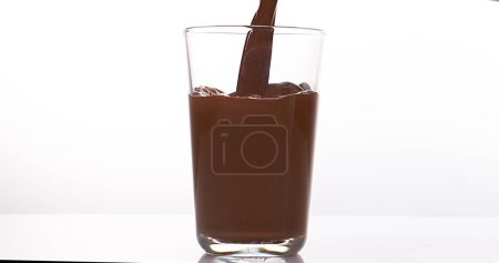 Téléchargez les photos : Chocolat Verser dans un verre sur fond blanc - en image libre de droit