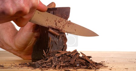 Téléchargez les photos : Homme coupe chocolat noir avec couteau - en image libre de droit