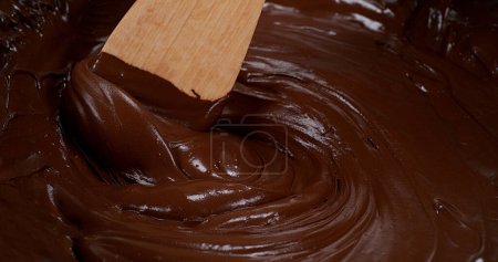 Téléchargez les photos : Cuillère en bois tournant chocolat au lait - en image libre de droit