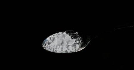 Téléchargez les photos : Drogue, Cocaïne dans la cuillère sur fond noir - en image libre de droit