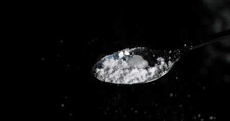 Téléchargez les photos : Drogue, Cocaïne dans la cuillère sur fond noir - en image libre de droit