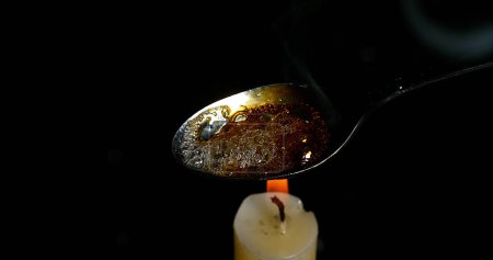 Téléchargez les photos : Drogue, Cocaïne dans une cuillère avec Bougie sur fond noir - en image libre de droit