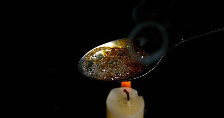 Téléchargez les photos : Drogue, Cocaïne dans une cuillère avec Bougie sur fond noir - en image libre de droit