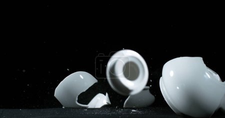 Photo for Tea-Pot falling and exploding on Black Background - Royalty Free Image