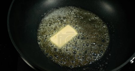 Téléchargez les photos : Beurre qui fond et crépite dans un poêle. - en image libre de droit