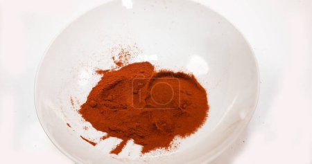Photo for Paprika, capsicum annuum, Powder falling into a Bowl against White Background - Royalty Free Image