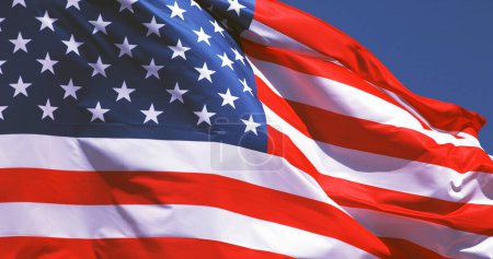 Foto de Bandera americana ondeando en el viento contra el cielo azul - Imagen libre de derechos