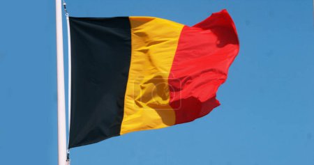 Foto de Bandera belga ondeando en el viento contra el cielo azul - Imagen libre de derechos