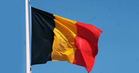 Foto de Bandera belga ondeando en el viento contra el cielo azul - Imagen libre de derechos