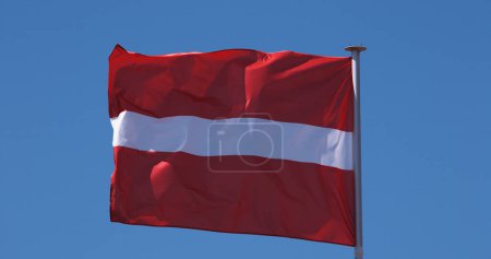 Foto de Bandera de Letonia ondeando en el viento contra el cielo azul - Imagen libre de derechos